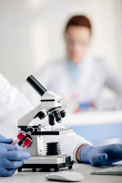 Cropped view of genetic consultant holding test tubes in lab — Stock Photo