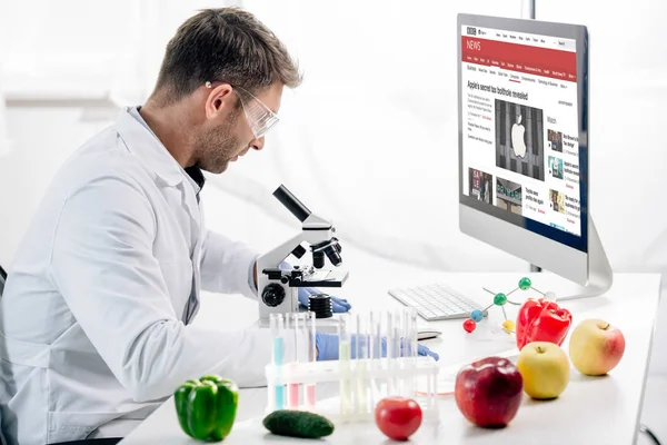 Kyiv, Ukraine - 4. Oktober 2019: Seitenansicht eines molekularen Ernährungswissenschaftlers am Computer mit bbc-Website — Stockfoto