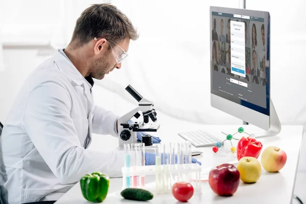 KYIV, UKRAINE - OCTOBER 4, 2019: side view of molecular nutritionist using computer with linkedin website — Stock Photo
