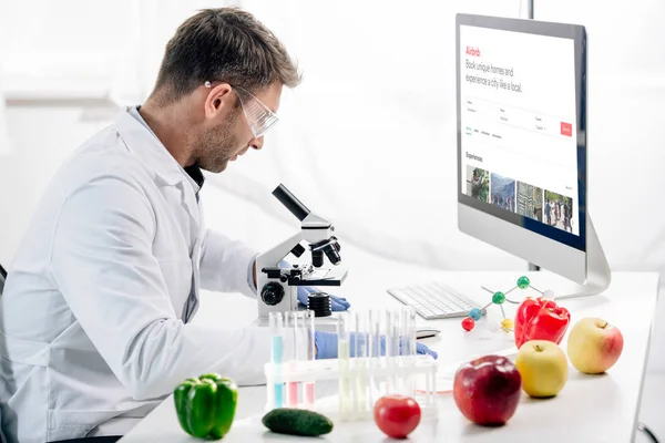 KYIV, UKRAINE - OCTOBER 4, 2019: side view of molecular nutritionist using computer with airbnb — Stock Photo