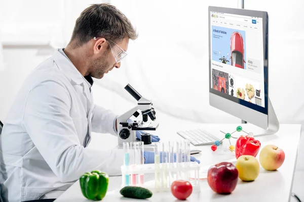 KYIV, UKRAINE - OCTOBER 4, 2019: side view of molecular nutritionist using computer with ebay website — Stock Photo