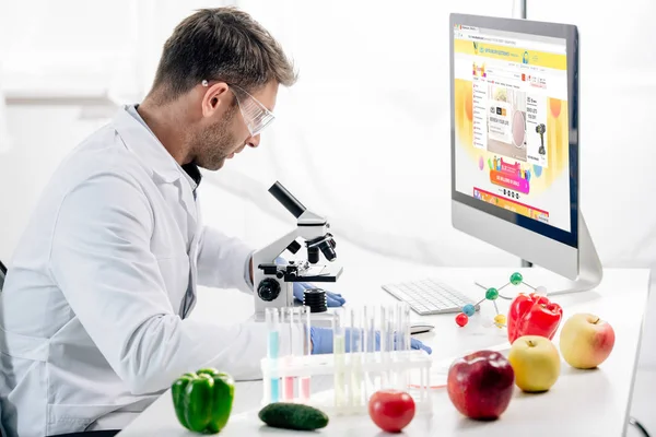 KYIV, UKRAINE - OCTOBER 4, 2019: side view of molecular nutritionist using computer with aliexpress website — Stock Photo