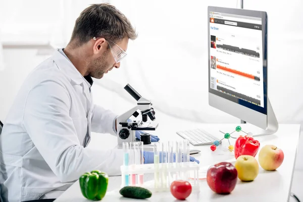 KYIV, UKRAINE - OCTOBER 4, 2019: side view of molecular nutritionist using computer with soundcloud website — Stock Photo
