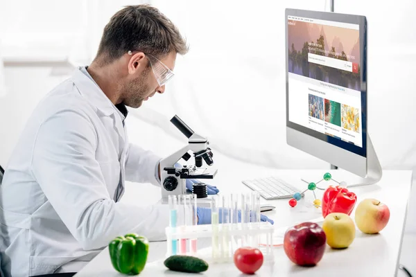 Kyiv, Ukraine - 4. Oktober 2019: Seitenansicht eines molekularen Ernährungswissenschaftlers am Computer mit Shutterstock-Website — Stockfoto