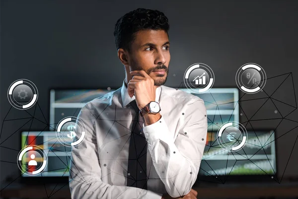 Pensive bi-racial trader looking away near bubbles with charts and graphs in office — Stock Photo