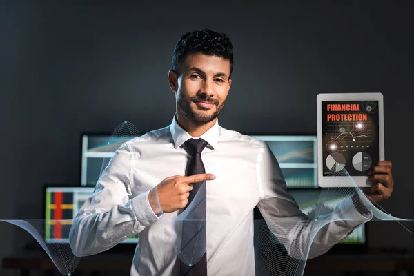 Comerciante bi-racial feliz apontando com o dedo para tablet digital com cartas de proteção financeira na tela — Fotografia de Stock