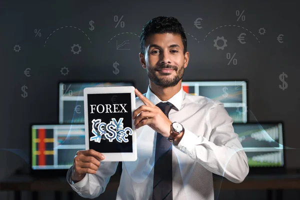 Comerciante bi-racial feliz segurando tablet digital com cartas forex — Fotografia de Stock