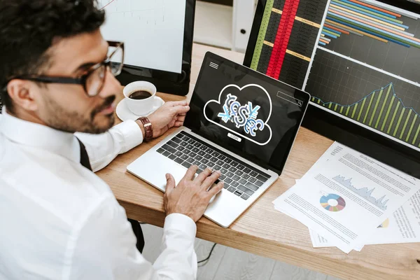 Selective focus of bi-racial trader using laptop with login letters — Stock Photo