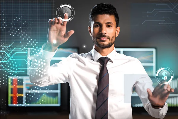 Selective focus of handsome bi-racial trader pointing with fingers near computers — Stock Photo