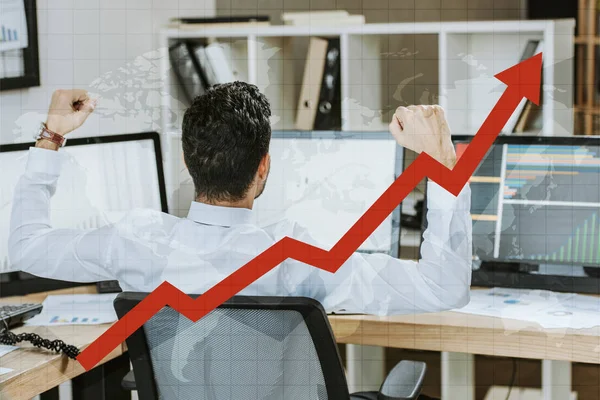 Back view of trader showing yes gesture and sitting near computers with graphs — Stock Photo