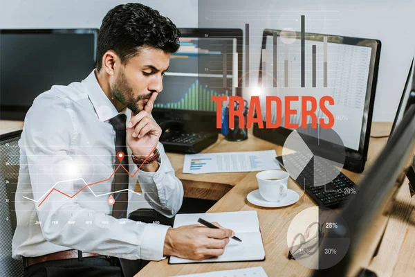 Pensive bi-racial man writing in notebook and sitting at table near traders letters — Stock Photo