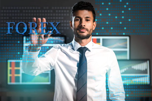 Bi-racial trader gesturing and looking at camera near forex letters — Stock Photo