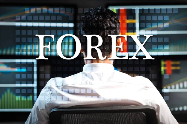 Back view of trader near computers with graphs and forex letters — Stock Photo