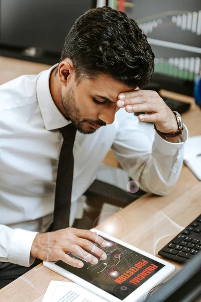 Pensive bi-racial trader using digital tablet with financial protection letters — Stock Photo