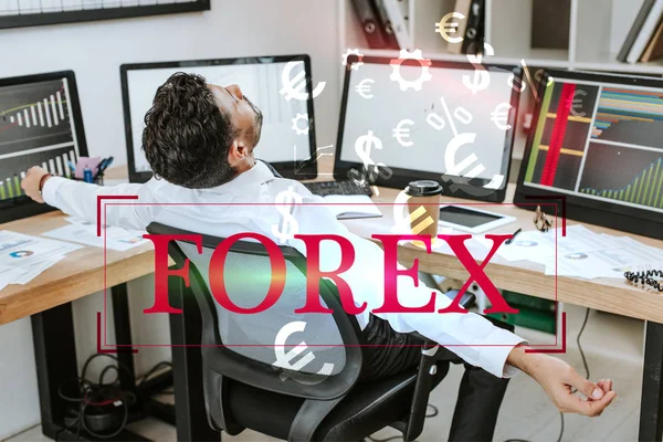 Bi-racial trader with outstretched hands sitting near computers and forex letters — Stock Photo