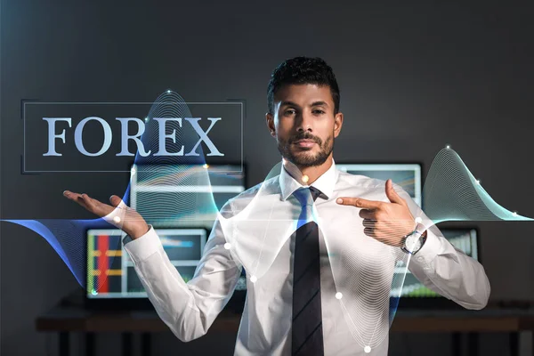 Bi-racial trader pointing with finger at forex letters — Stock Photo