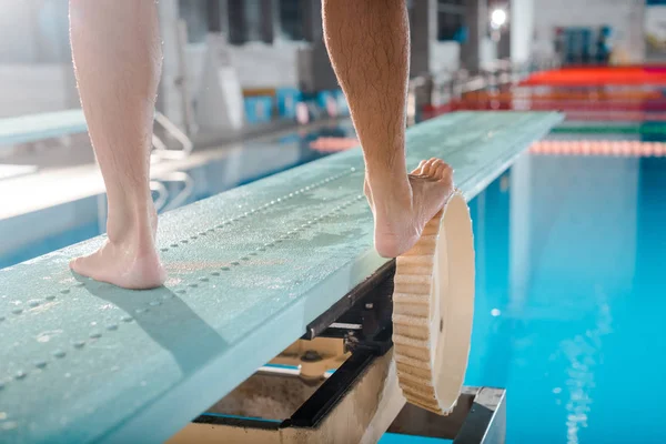 Cropped view of swimmer standing on diving board — Stock Photo