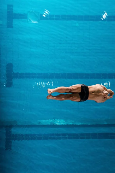 Top view of muscular swimmer diving into water — Stock Photo
