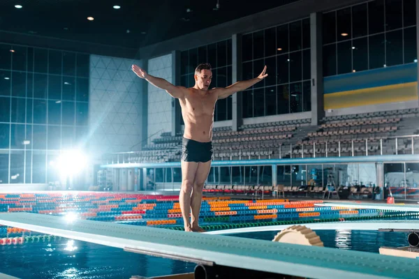 Muskulöser Schwimmer mit ausgestreckten Händen stehend — Stockfoto