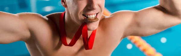 Tiro panorámico de nadador feliz con medalla de oro en los dientes - foto de stock