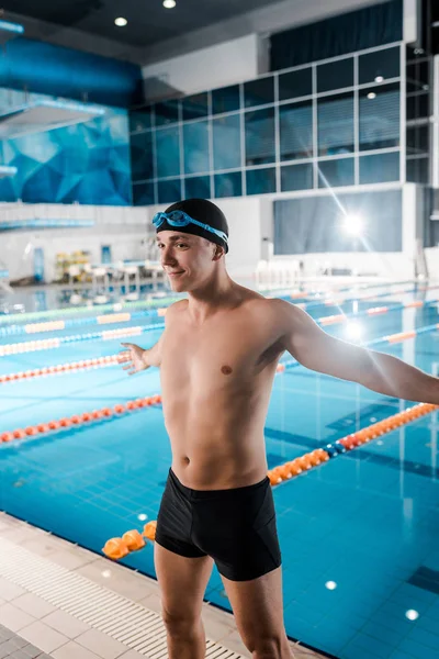 Happy man standing with outstretched hands near swimming pool — Stock Photo