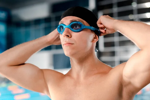 Nadador sem camisa em touca de natação usando óculos — Fotografia de Stock