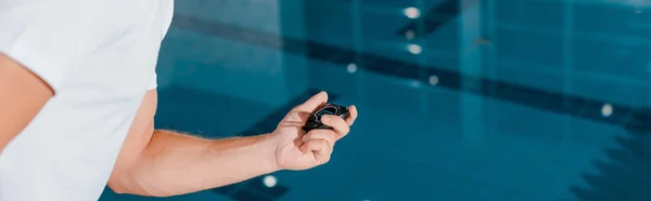 Panoramaaufnahme eines Sportlers mit Zeitschaltuhr in der Nähe eines Schwimmbades — Stockfoto