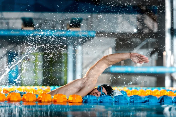 Gotas de agua cerca del entrenamiento de nadador guapo en la piscina - foto de stock