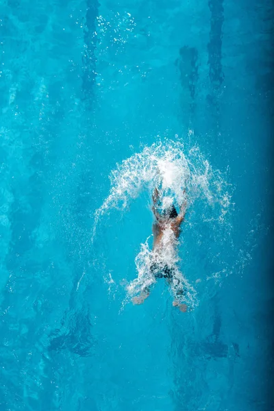 Vue de dessus du nageur plongeant dans l'eau dans la piscine — Photo de stock