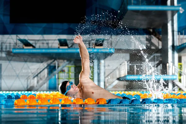 Gotas de água perto de treinamento atlético nadador na piscina — Fotografia de Stock