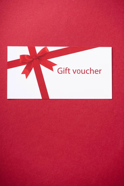 Top view of gift voucher on red background with copy space — Stock Photo