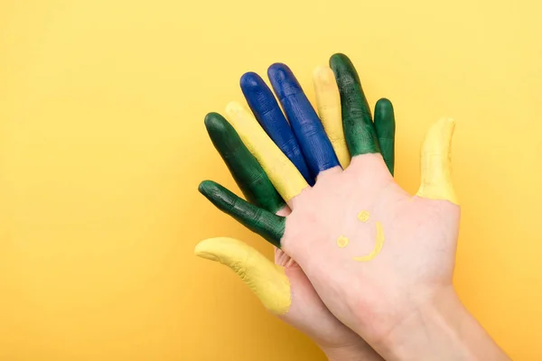 Cropped view of man with colorful fingers on yellow background — Stock Photo