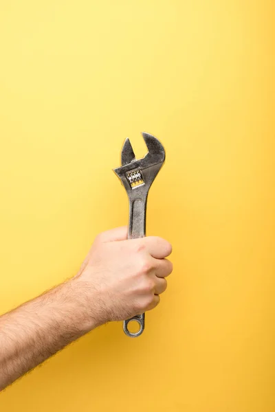 Corte vista de homem segurando chave no fundo amarelo — Fotografia de Stock