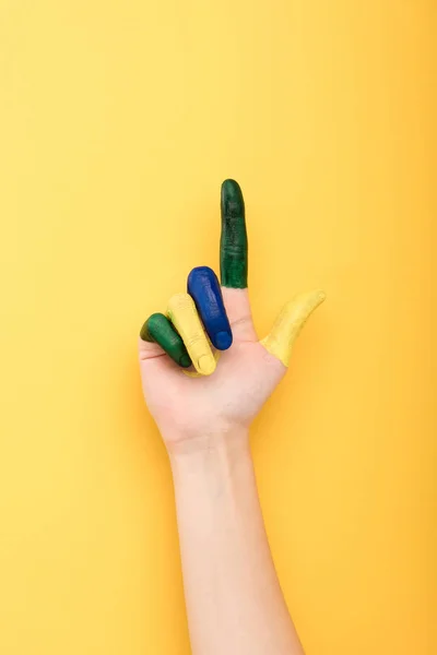 Vista recortada de la mujer con los dedos de colores que muestran gesto idea aislado en amarillo - foto de stock