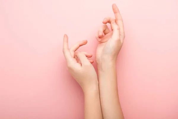 Обрезанный вид женщины, показывающей руки на розовом фоне — стоковое фото