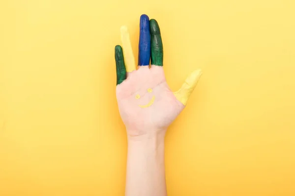 Vista recortada de la mujer con los dedos de colores que muestran la palma aislada en amarillo - foto de stock