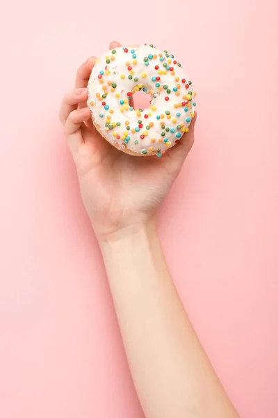 Cropped view of woman holding donut on pink background — Stock Photo