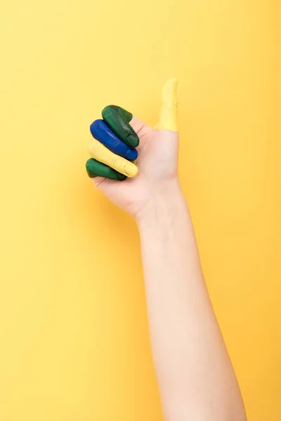 Vista cortada de mulher com dedos coloridos mostrando como no fundo amarelo — Fotografia de Stock