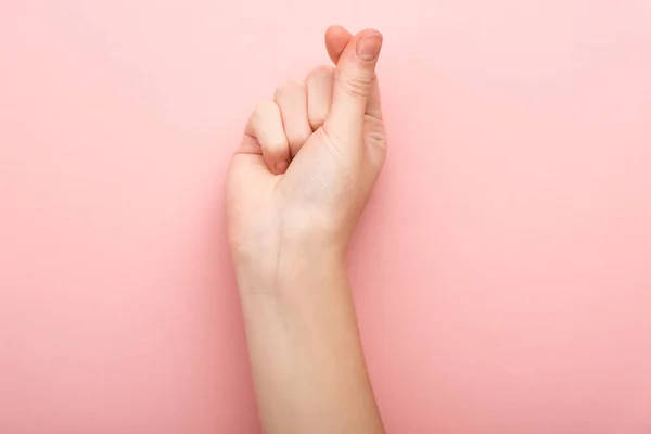 Vista ritagliata della donna che mostra il gesto del cuore su sfondo rosa — Foto stock