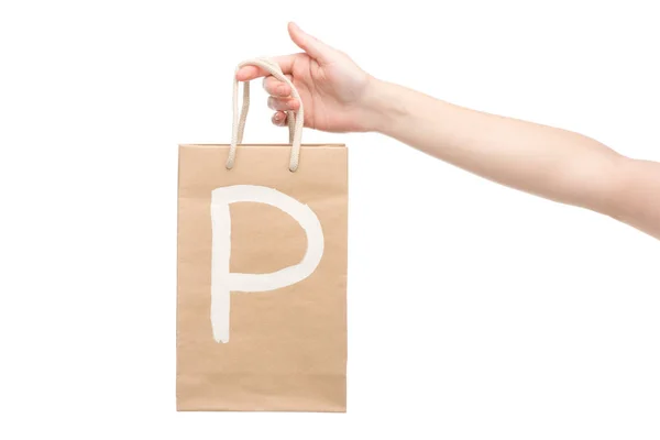 Vista ritagliata della donna in possesso di shopping bag con lettera p isolato su bianco — Foto stock