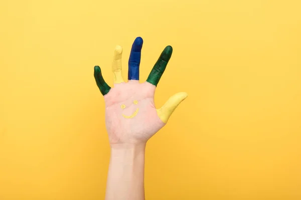 Обрізаний вид жінки з різнокольоровими пальцями, що показують долоню ізольовано на жовтому — стокове фото