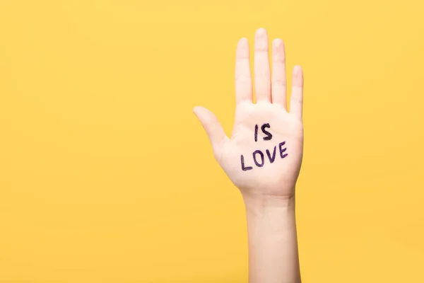 Vista ritagliata della donna con è lettering amore a portata di mano isolato su giallo — Foto stock