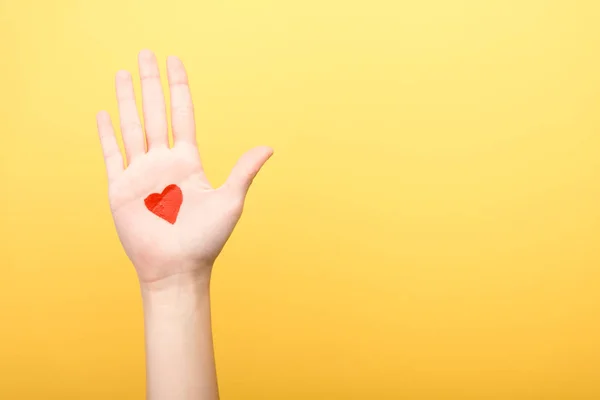 Vista recortada de la mujer con el corazón pintado aislado en amarillo - foto de stock