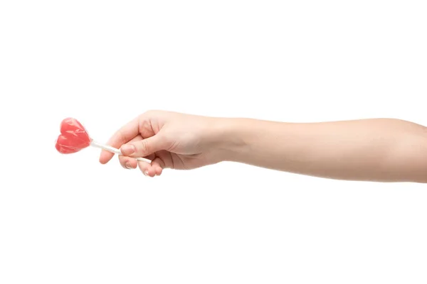 Vista ritagliata di donna che tiene lecca-lecca a forma di cuore isolato su bianco — Foto stock