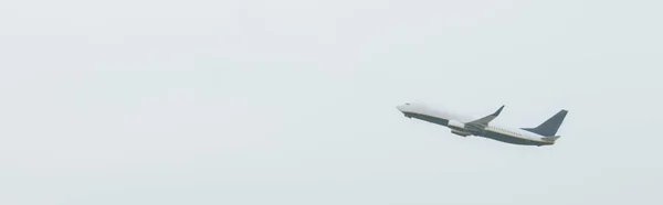 Low angle view of airplane in cloudy sky, panoramic shot — Stock Photo