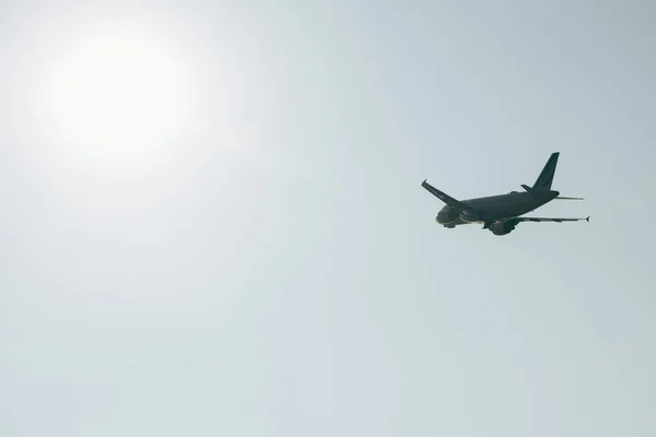 Vista de ángulo bajo del avión en el cielo despejado con sol — Stock Photo