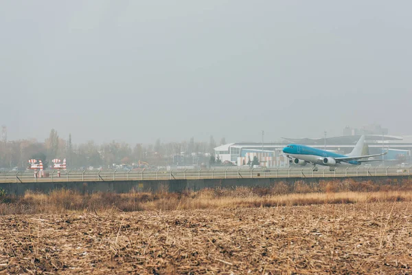 Flugzeug auf Landebahn in Feld mit bewölktem Himmel im Hintergrund — Stockfoto