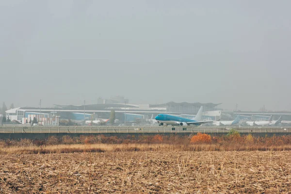 Avion commercial sur piste dans un champ avec ciel nuageux en arrière-plan — Photo de stock