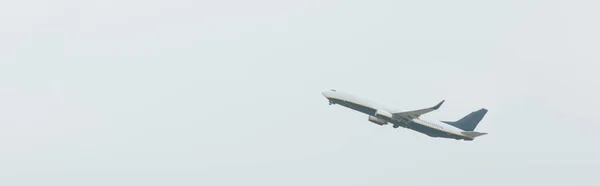 Foto panorámica de jet comercial en cielo nublado - foto de stock