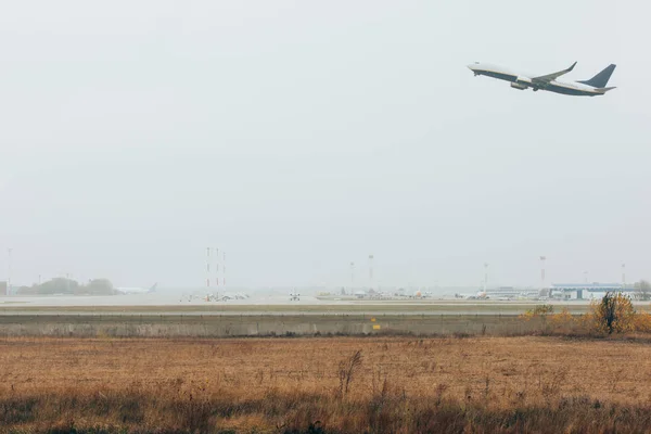 Saída de avião no aeródromo com céu nublado ao fundo — Fotografia de Stock